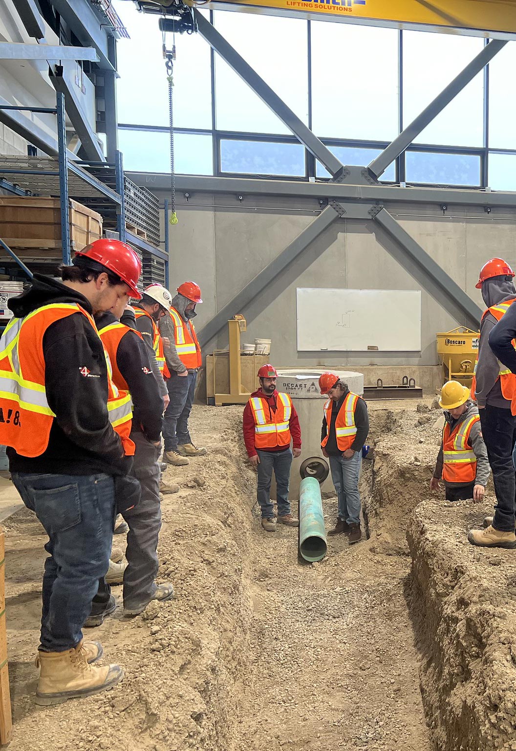 Construction workers in orange vests and hard hats, actively engaged in their tasks