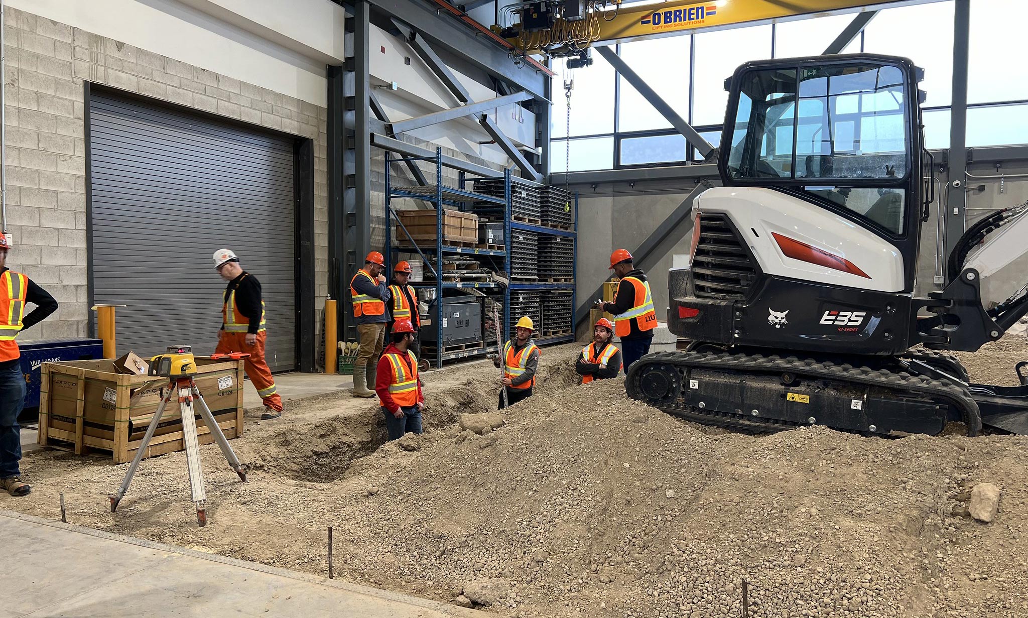 Several construction workers collaborating around a machine, focused on their tasks at the construction site.