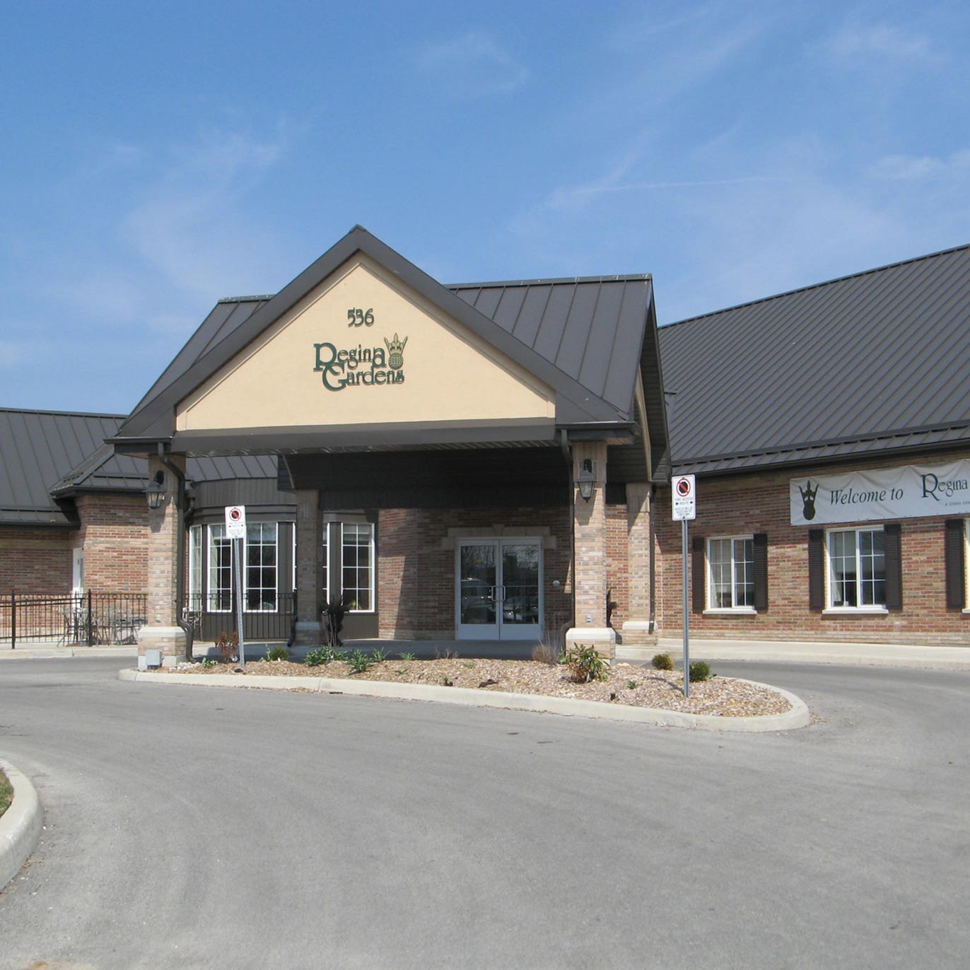 A large building featuring a prominent sign on its facade that reads Regina Gardens